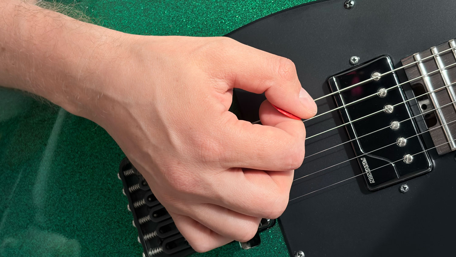 Side view of picking hand with light palm contact near the bridge