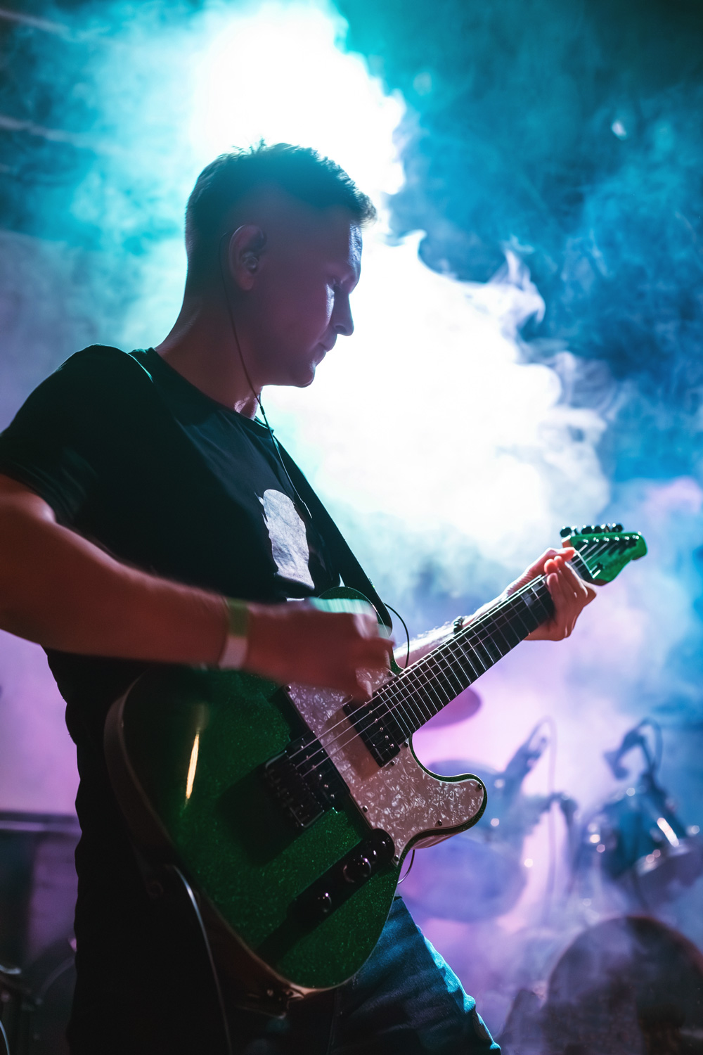 Andrew Nitsievsky playing a live gig on stage with a green Telecaster guitar